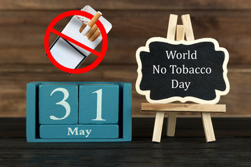 wooden calendar with the date of May 31 and a sign prohibiting smoking on a wooden background, World No Tobacco Day