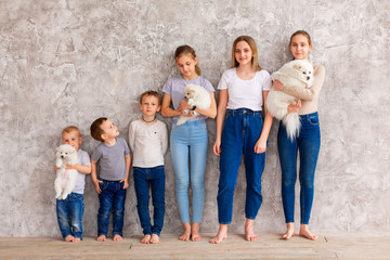 Obraz premium Happy children of different age with puppies standing in line