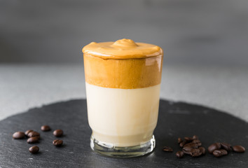 Dalgona coffee whipped cream mousse against grey background, also dubbed as quarantine drink