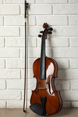 Classic violin and bow near white brick wall