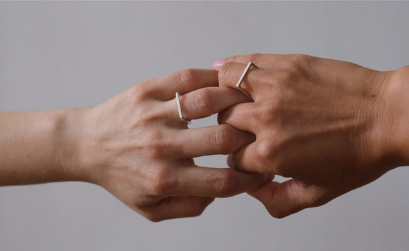 mains de femmes avec bagues entrem&ecirc;l&eacute;es 