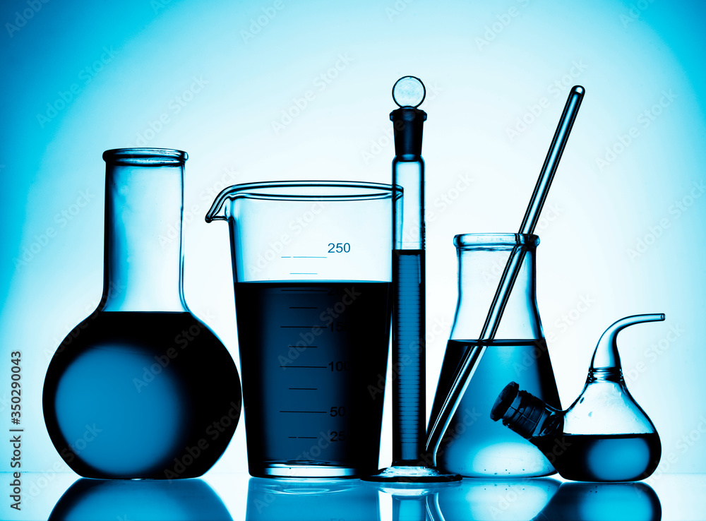 Wall mural different laboratory glassware with color liquid and with reflection