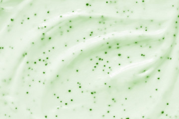 Face cream scrub texture background. Green color exfoliating skincare product smear smudge swatch. Gentle creamy scrub cleanser strokes closeup - obrazy, fototapety, plakaty