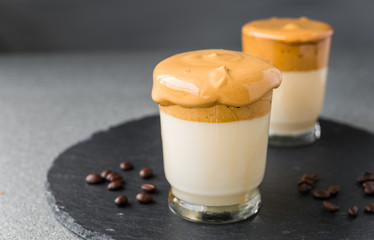 Dalgona coffee whipped cream mousse against grey background, also dubbed as quarantine drink