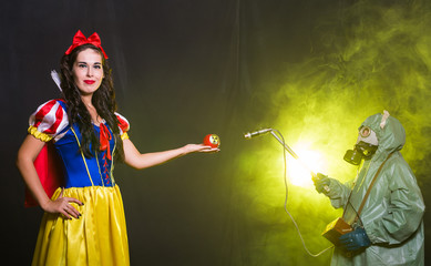 Woman wearing a fairy tale dress holding an apple with radiation symbol. Environmental problems...