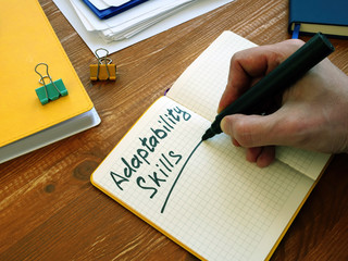 Adaptability Skills written by man on the sheet.