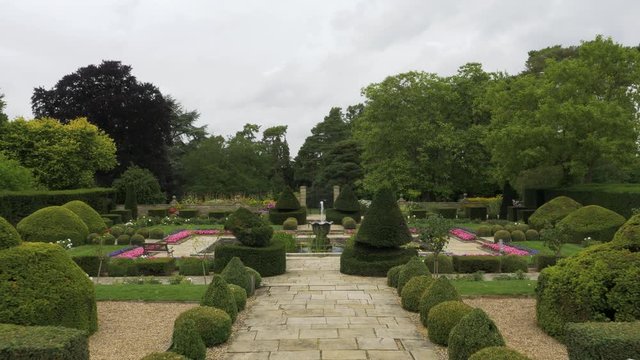Smooth walking movement into symmetrical gardens toward water feature