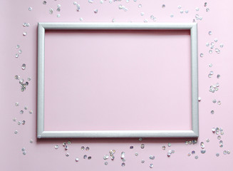 Empty frame silver with the confetti and space for text on pink background.