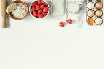 The recipe for strawberry pie. Raw materials for making strawberry pie or cake on a white background with copy space (eggs, flour, milk, cottage cheese, strawberries), top view, flat lounger, bakery