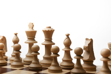 army of white chess pieces on the board at the beginning of the game on white background. 