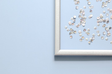 Part of the silver frame is decorated with confetti with space for text on blue background.