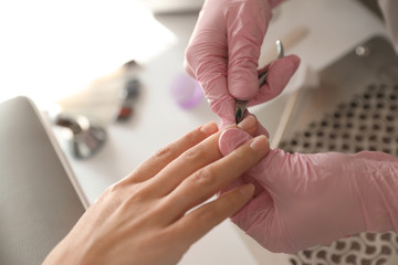 Professional manicurist working with client in beauty salon, above view