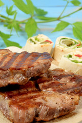 grilled meat on a kitchen board with pieces of colorful tortilla