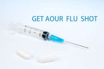 GET AOUR FLU SHOT ,flu, syringe, pills. Copy space for text.