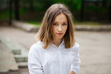 Portrait of a young blonde girl in white t-shirt and blue jeans