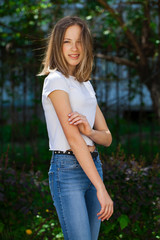 Portrait of a young blonde girl in white t-shirt and blue jeans