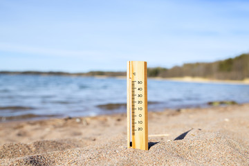 A thermometer on the beach near the sea to check the temperature.