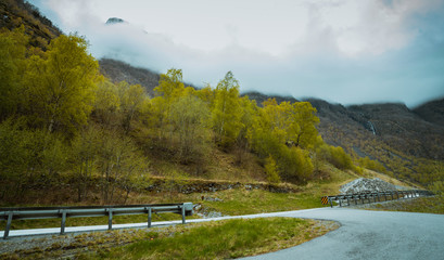 Asfaltowa droga prowadząca między wysokimi ośnieżonymi górami © Dreamnordno