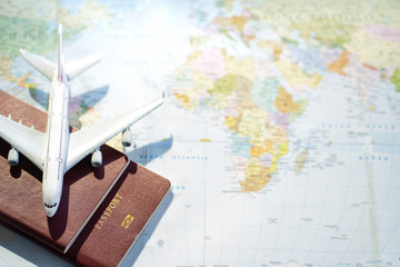 Passport with a map background.Travel planning.Top view of traveler accessories with a plane  on world map.Preparation for travel.Traveling Journey Vacation Holiday concept.