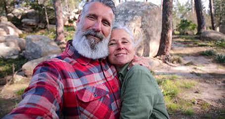 Close up senior couple hugging taking selfie in forest - Powered by Adobe