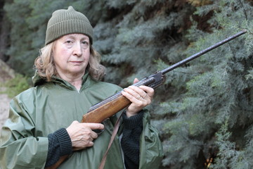 Mature huntress holding a rifle