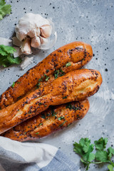 Vertical photo of garlic baguettes with fresh garlic and parsley 