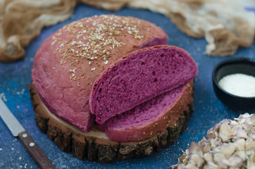 Lilac bread on a board with sesame seed