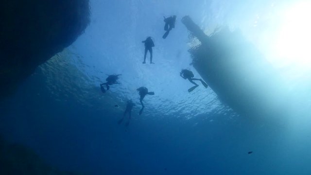 underwater scenery of scuba divers with boat end or begining of dive 
