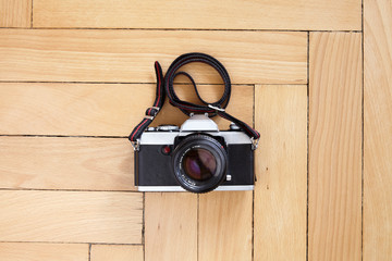 Old camera on wooden parquet floor