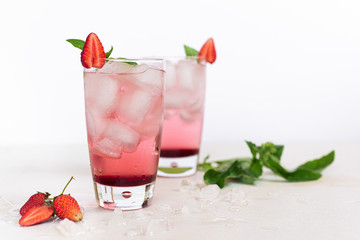 Two glasses of strawberry basil lemonade on white background with copy space 