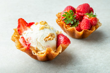Vanilla Ice Cream Scoops with strawberry pieces into the waffle basket, easy dessert at home