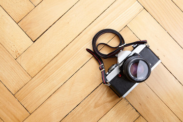 Old reflex camera on wooden parquet floor