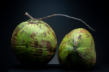Pair of brightly lit vibrant green exotic palm coconut fruit drupes from the local Brazilian market...