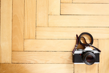 Old type camera on herringbone wooden parquet floor