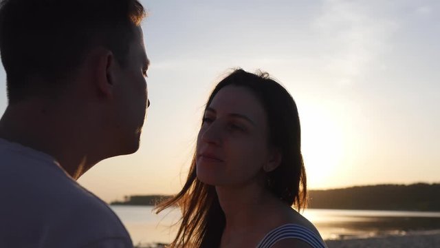 A young couple wearing protective masks and takes them off and kissing outdoors rejoicing over the end of the coronovirus. Virus Prevention and People Concept.