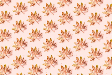 Beautiful Leaf Pattern. Leaves are painted in golden and copper metallic paint on pink background. Autumn minimalism. Isometric flat lay.