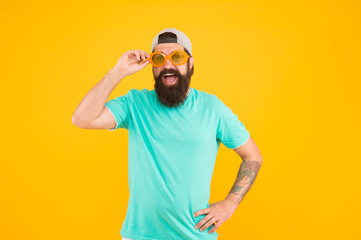 Hipster wear party sunglasses. Eyes health. Bearded man in sunglasses orange background. Eyesight...