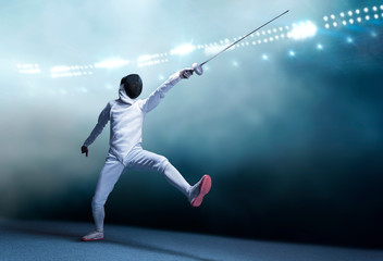 The fencer moves forward with a sword in his hand. Sport concept.