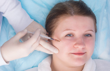 cosmetology, hands in sterile gloves make an injection of beauty to a woman, in the front part