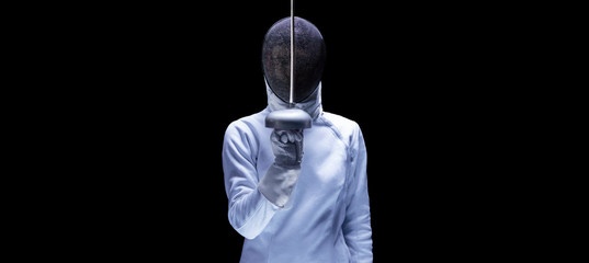 Charming girl dressed as a fencer posing with a mask and a sword. The concept of fencing.