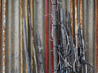 Rods and poles leaned against a corrugated wall