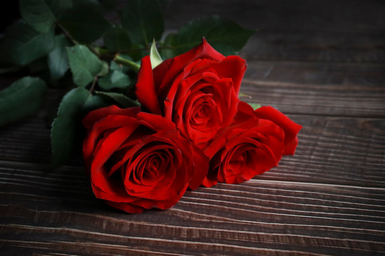 red roses on a wooden background, beautiful picture, card. selective focus, vignetting
