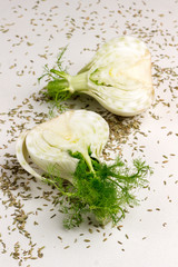 Two halves of fennel bulb, fennel seeds on table. Healthy food.