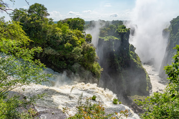 Victoria Falls on Zambezi River, border of Zambia and Zimbabwe with a dramatic sky  and  rain forest