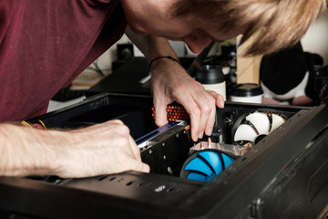 Man repairs a computer system unit, changes parts, video card and hard drive. Computer Repair Wizard.