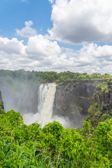 Victoria Falls on Zambezi River, border of Zambia and Zimbabwe with a dramatic sky  and  rain forest