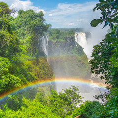 Rainbow at the Victoria Falls on Zambezi River, border of Zambia and Zimbabwe with steam and a...