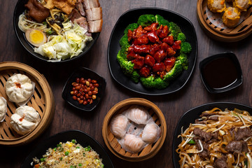 Flat lay of Chinese dishes including General Tso Chicken and steamed dumplings