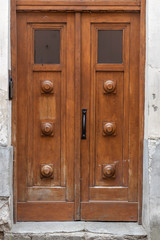 Vintage brown wooden door of a house in an old European city.