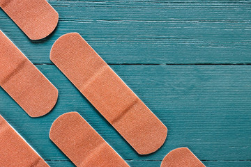 Angled Rows of Adhesive Bandages on Turquoise Background with Space for Copy